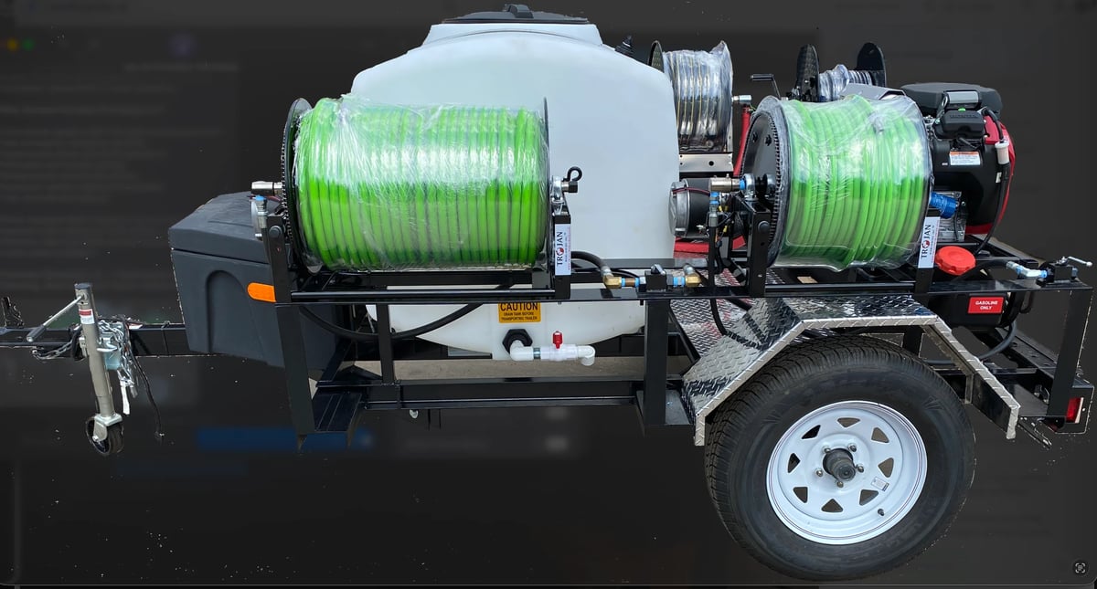 Trailer-mounted spray system with white tank and green hose reels on black frame with white wheels